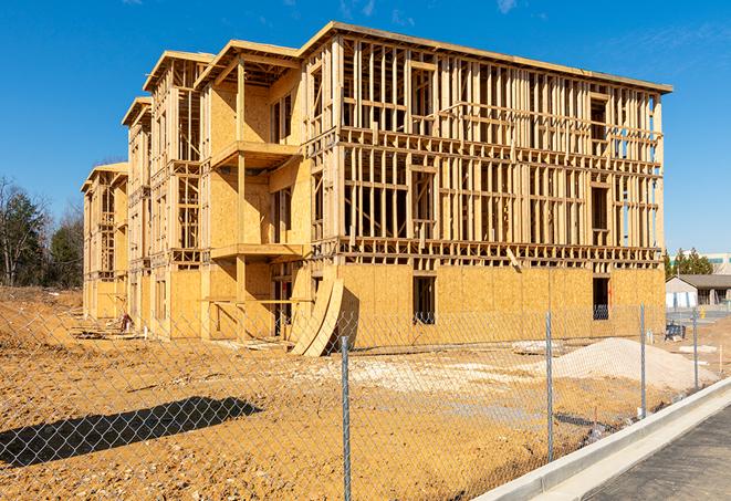 a temporary chain link fence in front of a building under construction, ensuring public safety in Flower Mound